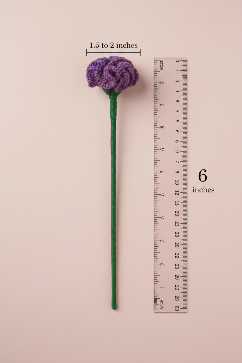 A single purple crocheted flower stem with a green stem is shown on a pale pink background, alongside a ruler indicating the stem is 6 inches long and the flower head is 1.5 to 2 inches wide.