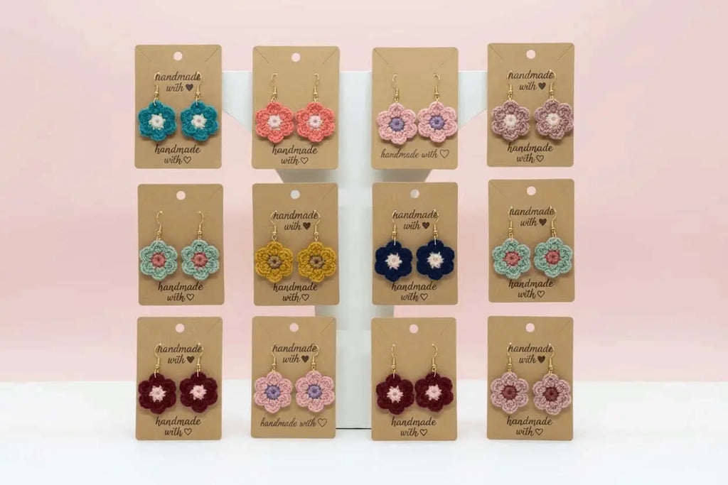 Multi colored shape shaped flower dangles on a brown display card with writing made with ❤️