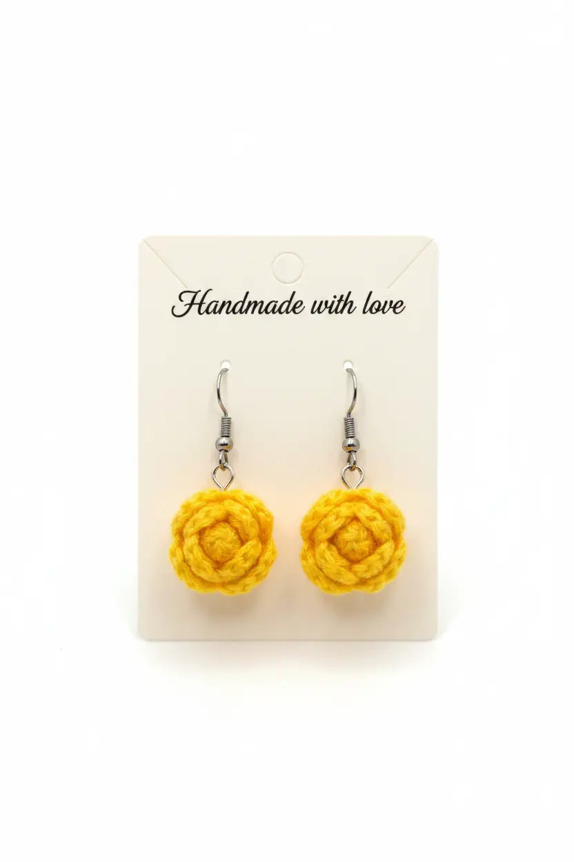 A pair of handmade yellow crochet rose dangle earrings on a white display card that reads 'Handmade with love'.