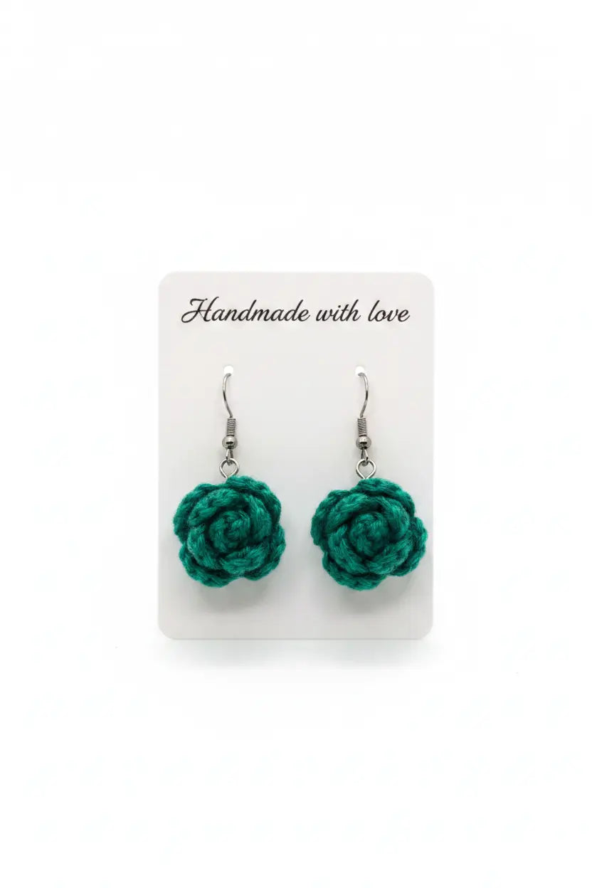 A pair of handmade green crochet rose drop earrings on a white display card that reads 'Handmade with love'.