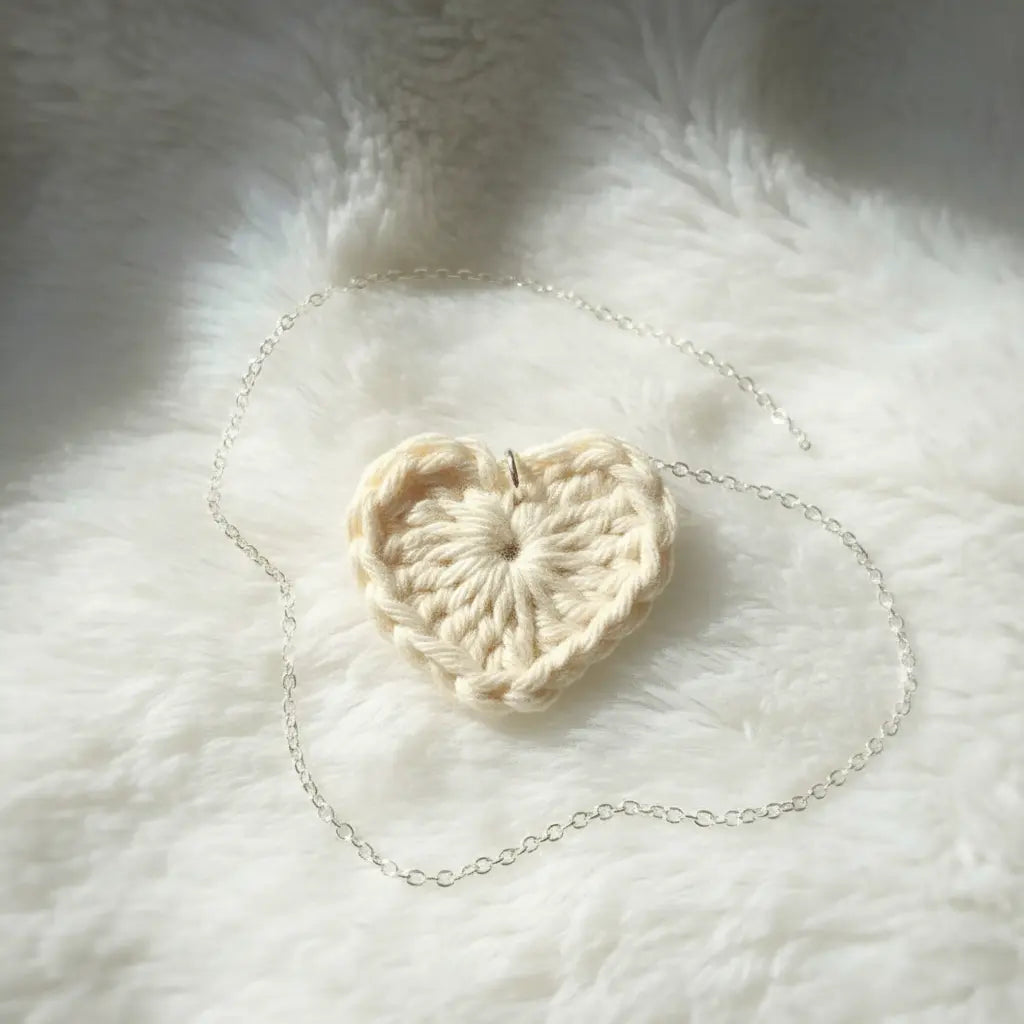 Crocheted heart-shaped object on a fluffy white surface